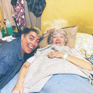 En la foto está Su junto a su abuelita que está en cama. Ambas están sonriendo.